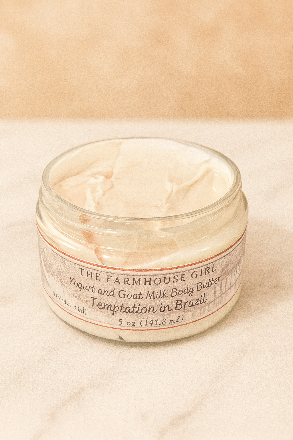 Jar of The Farmhouse Girl yogurt and goat milk body butter on a beige background